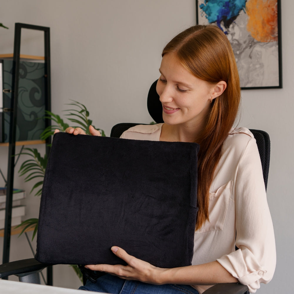 Kvinne som viser frem Korsryggstøtten fra Din Holdning